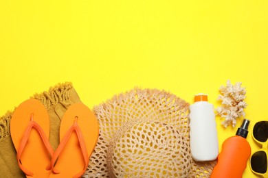 Photo of Flat lay composition with beach towel and other summer accessories on yellow background. Space for text