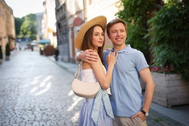 Photo of Lovely couple walking together on city street, space for text