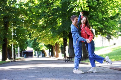 Photo of Lovely couple spending time together in park, space for text