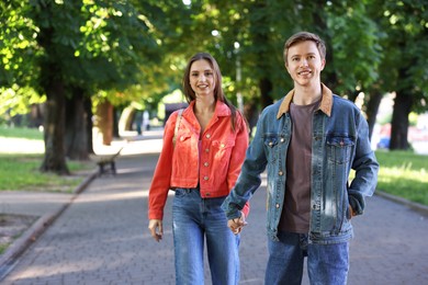 Photo of Lovely couple spending time together in park, space for text