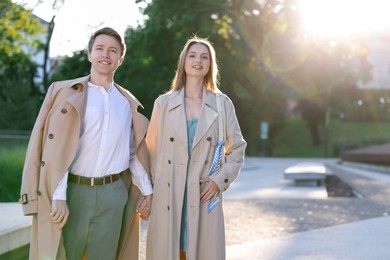 Photo of Lovely couple walking together on city street, space for text