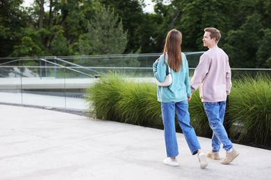 Photo of Lovely couple walking together on city street, space for text