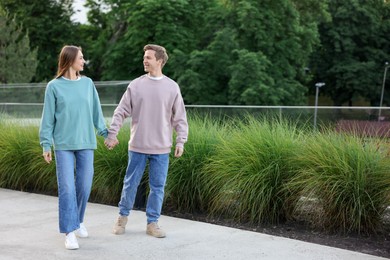 Photo of Lovely couple walking together on city street, space for text