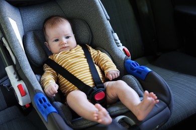 Photo of Cute little baby fastened in car seat