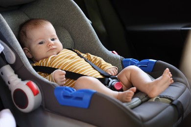 Photo of Cute little baby fastened in car seat
