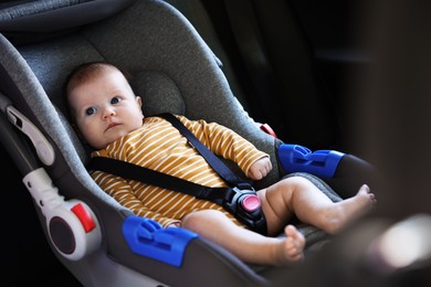 Photo of Cute little baby fastened in car seat