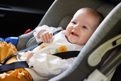 Photo of Cute little baby fastened in car seat