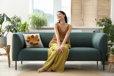 Photo of Harmony. Smiling woman relaxing on sofa at home
