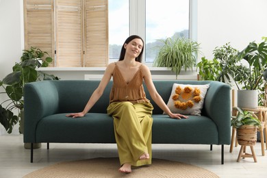Photo of Harmony. Smiling woman relaxing on sofa at home