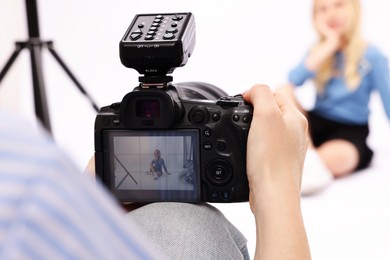 Photo of Photographer working with model in professional photo studio, selective focus