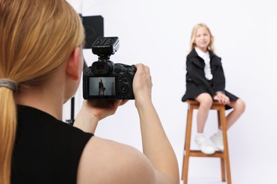 Photo of Photographer working with model in professional photo studio, selective focus
