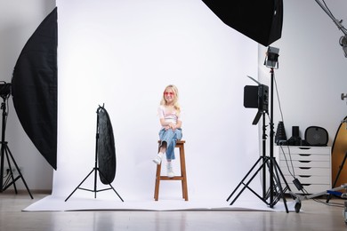 Photo of Little girl on white background in photo studio with professional equipment
