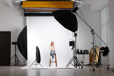 Photo of Little girl on white background in photo studio with professional equipment