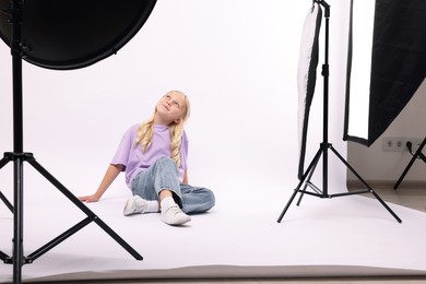 Photo of Little girl on white background in photo studio with professional equipment