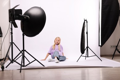 Photo of Little girl on white background in photo studio with professional equipment