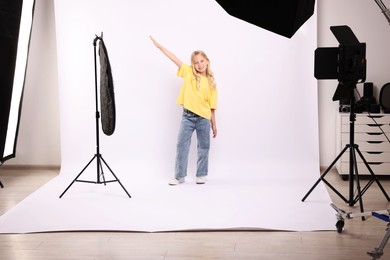 Photo of Little girl on white background in photo studio with professional equipment