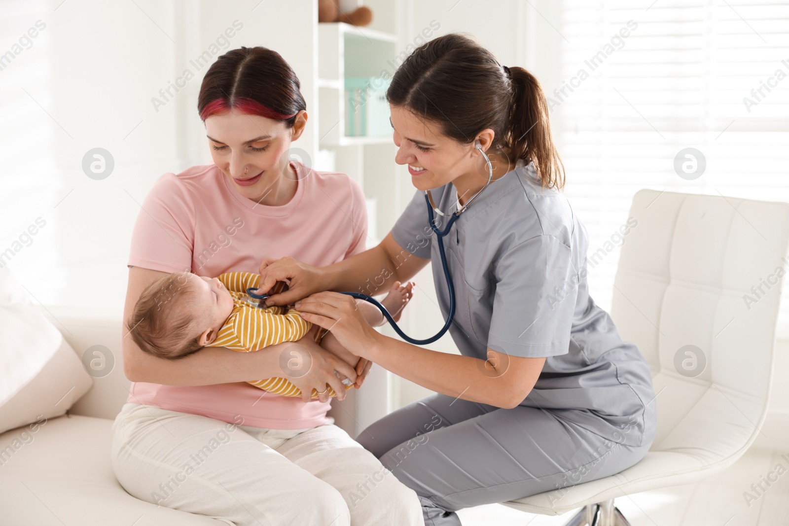 Mother and her cute little child having appointment with pediatrician in hospital. Doctor examining baby with stethoscope Photo of Mother and her cute little child having appointment with pediatrician in hospital. Doctor examining baby with stethoscope