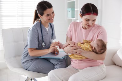 Photo of Mother and her cute baby having appointment with pediatrician in hospital