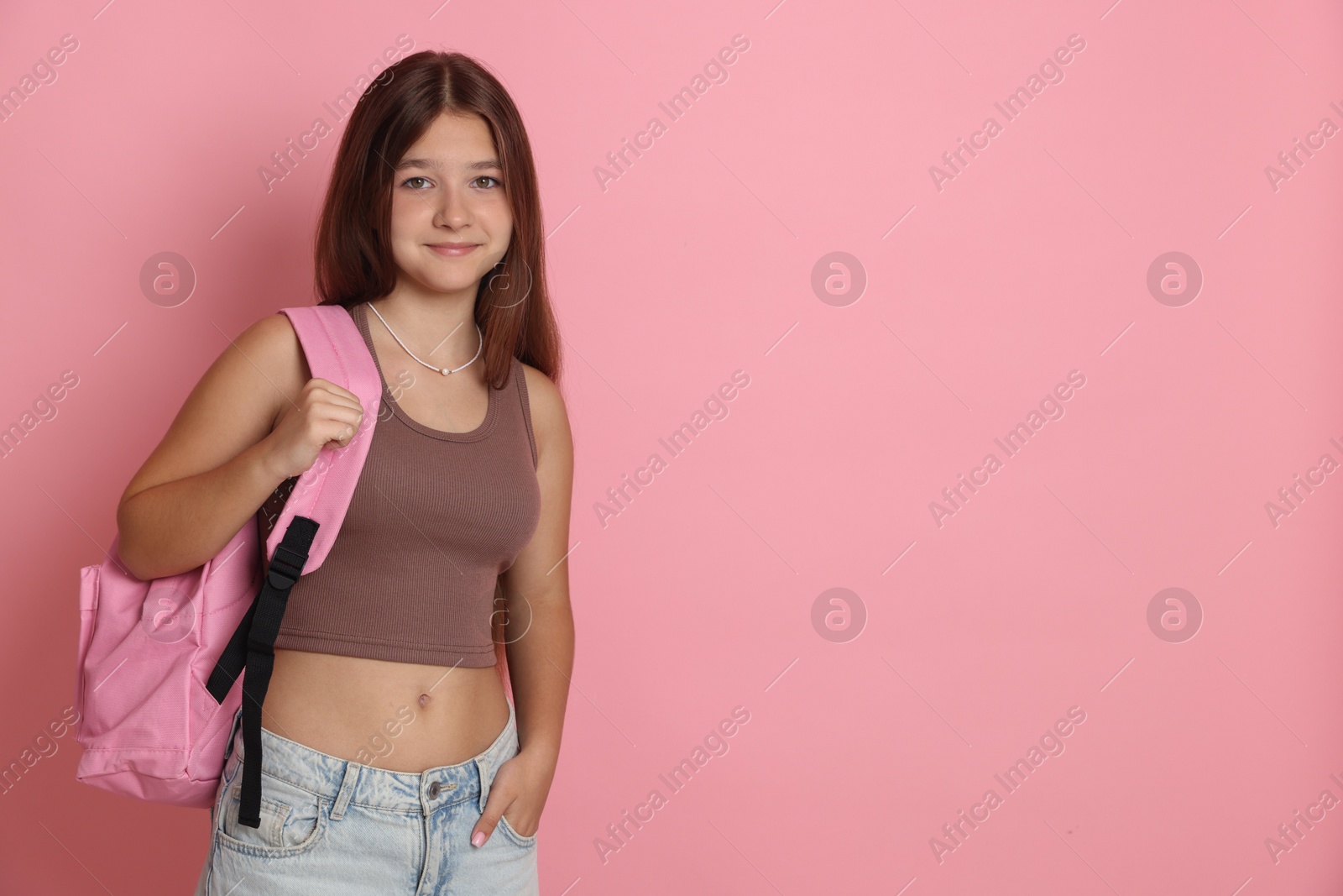 Photo of Teenage girl with backpack on pink background, space for text