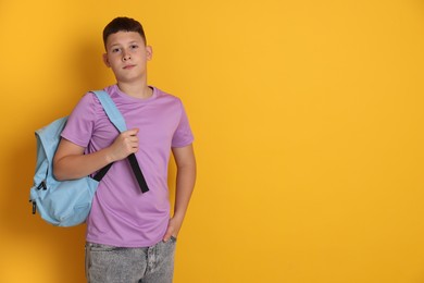 Photo of Teenage boy with backpack on orange background, space for text
