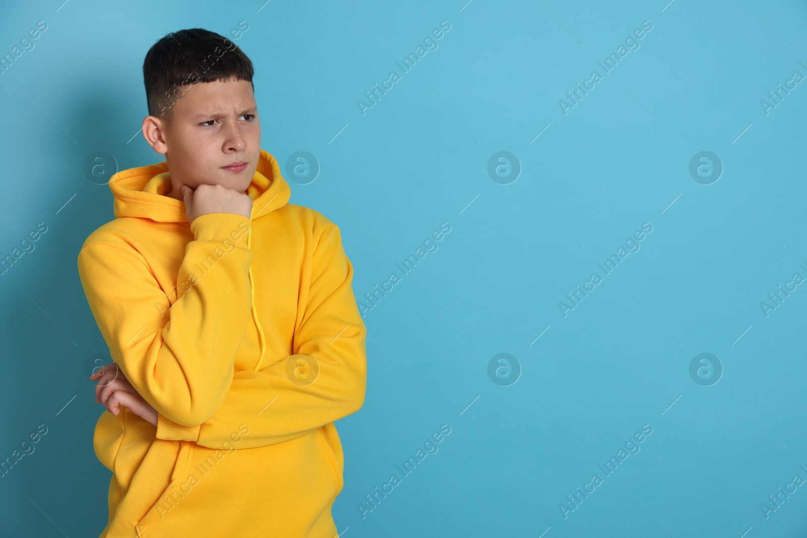 Portrait of teenage boy on light blue background, space for text Photo of Portrait of teenage boy on light blue background, space for text