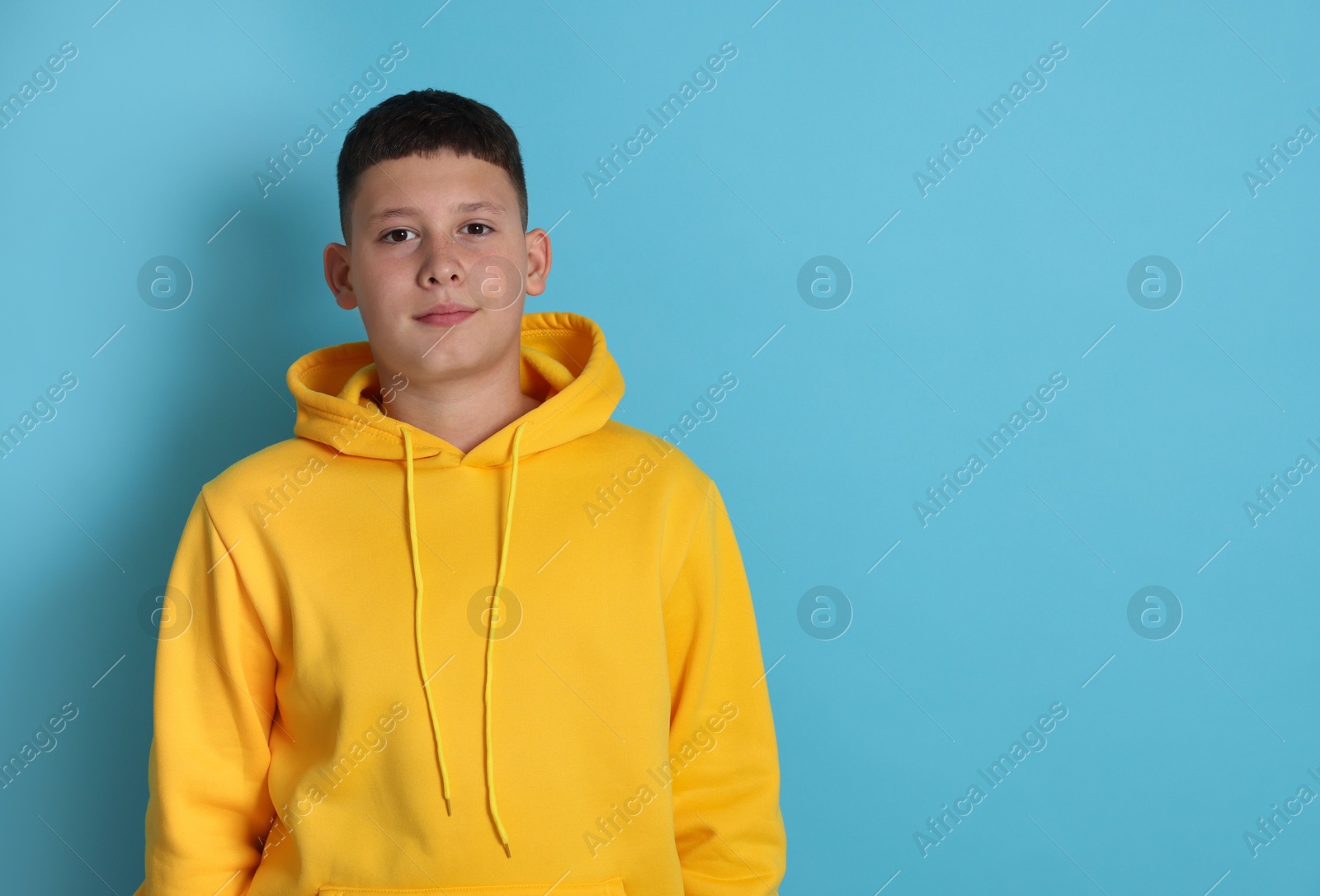 Portrait of teenage boy on light blue background, space for text Photo of Portrait of teenage boy on light blue background, space for text