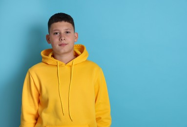 Photo of Portrait of teenage boy on light blue background, space for text