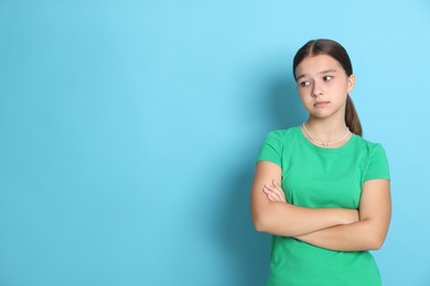 Photo of Portrait of teenage girl on light blue background, space for text