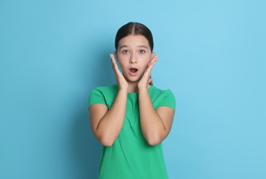 Photo of Portrait of shocked teenage girl on light blue background