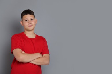 Photo of Portrait of teenage boy on grey background, space for text
