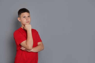 Photo of Portrait of teenage boy on grey background, space for text