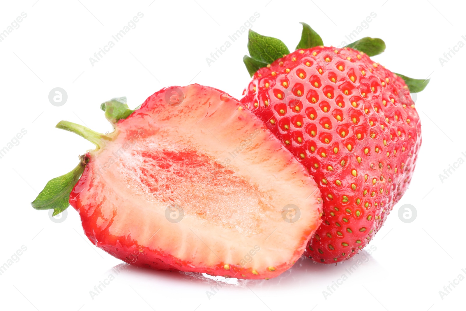 Whole and half of fresh strawberries isolated on white Photo of Whole and half of fresh strawberries isolated on white