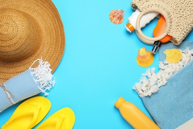 Photo of Flat lay composition with beach towel and other summer accessories on light blue background. Space for text