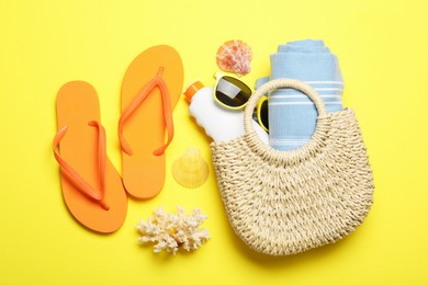 Photo of Flat lay composition with beach towel and other summer accessories on yellow background