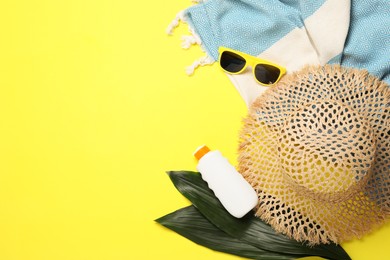 Photo of Flat lay composition with beach towel and other summer accessories on yellow background. Space for text