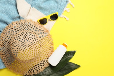Photo of Flat lay composition with beach towel and other summer accessories on yellow background. Space for text