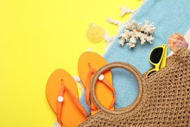 Photo of Flat lay composition with beach towel and other summer accessories on yellow background. Space for text