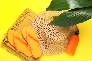 Photo of Flat lay composition with beach towel and other summer accessories on yellow background
