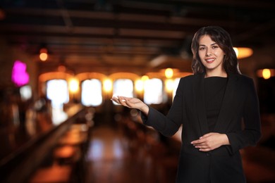 Image of Young hostess in uniform welcoming to restaurant