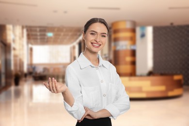 Image of Young hostess in uniform at hotel lobby