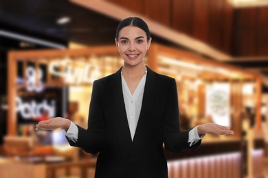 Image of Young hostess in uniform welcoming to restaurant