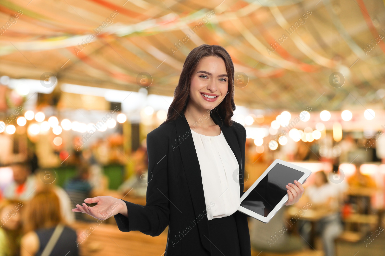 Young hostess with tablet computer welcoming to restaurant Image of Young hostess with tablet computer welcoming to restaurant