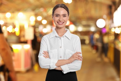 Image of Young smiling hostess wearing uniform in restaurant