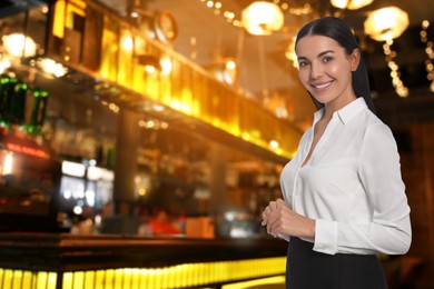 Image of Young smiling hostess wearing uniform in restaurant