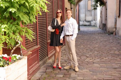 Photo of Lovely couple walking together on city street, space for text