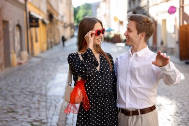 Photo of Lovely couple walking together on city street, space for text