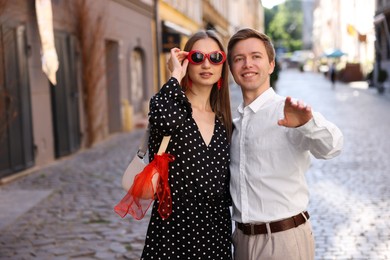 Photo of Lovely couple walking together on city street, space for text