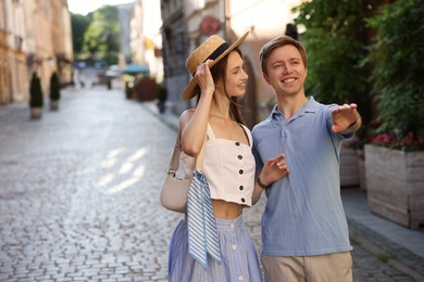 Photo of Lovely couple walking together on city street, space for text
