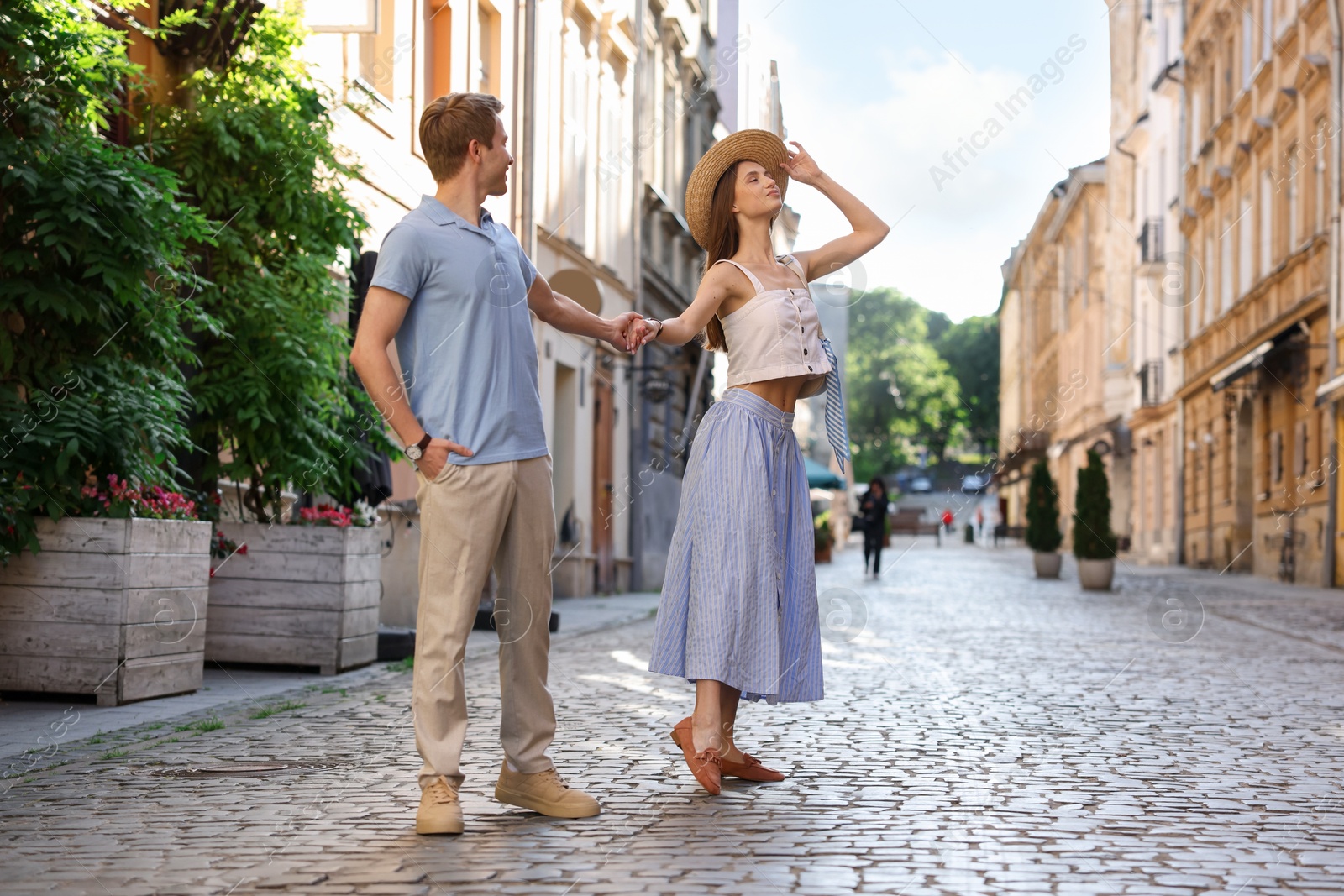 Photo of Lovely couple walking together on city street, space for text