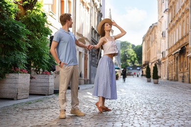 Photo of Lovely couple walking together on city street, space for text